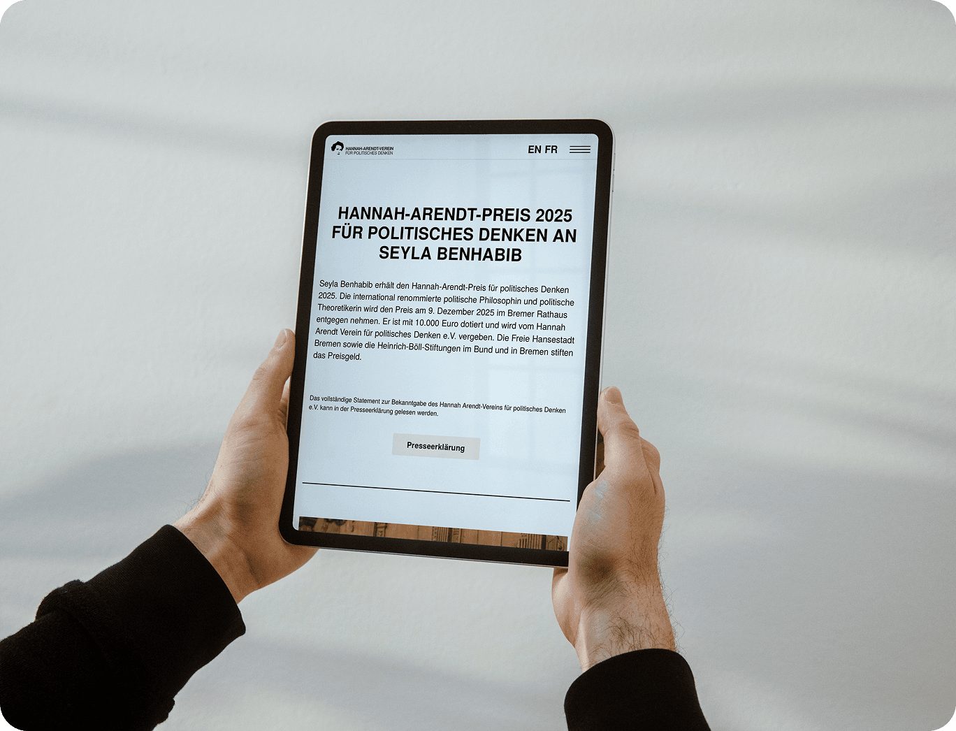 Ein Tablet wird in beiden Händen gehalten. Auf dem Display ist die Webseite des Hannah-Arendt-Preises zu sehen.