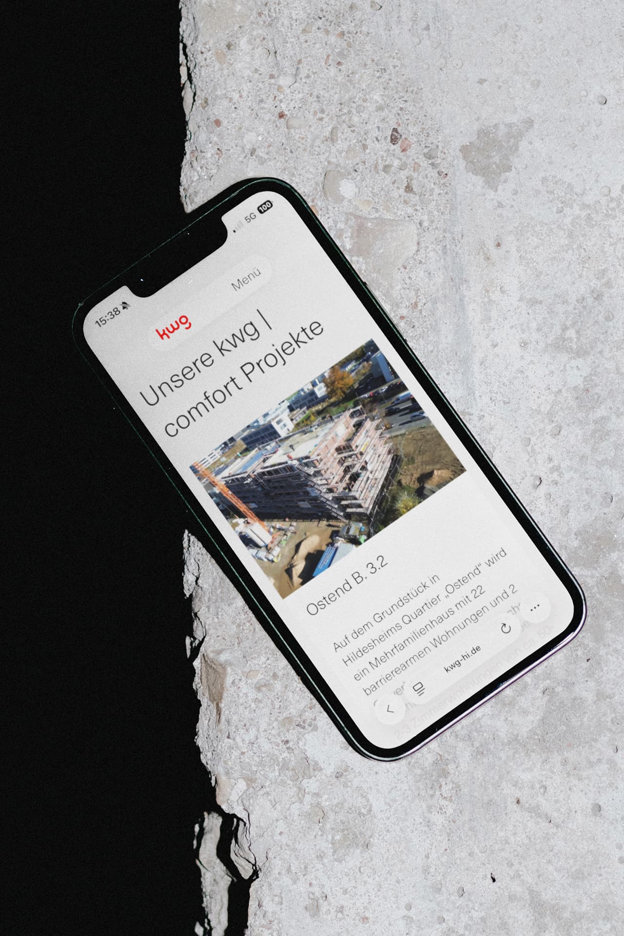 Ein iPhone liegt auf einem Untergrund auf Stein. Auf dem Display ist die Webseite der kwg Kreiswohnbaugesellschaft Hildesheim mbH geöffnet.